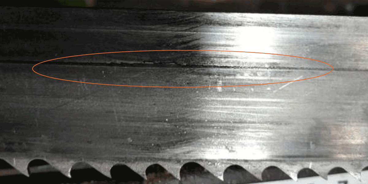 Band saw blade back edge scoring causes